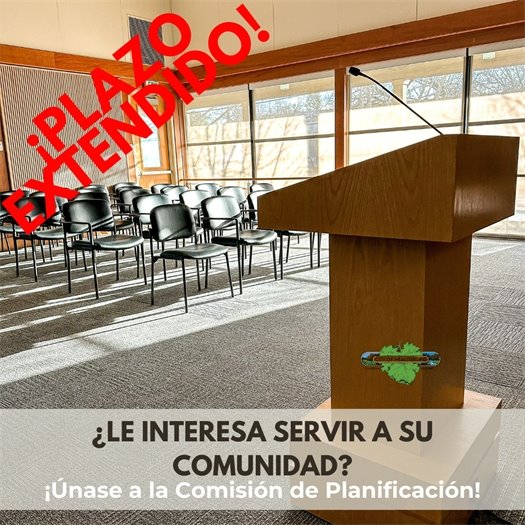 A picture of an empty Council Chamber with a podium and black chairs to sit in.