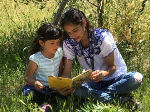Woman reading book to child in Open Space Preserve