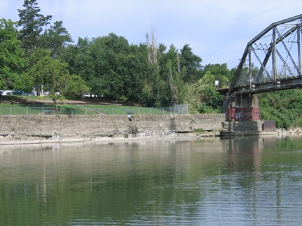 A bridge over a river in a wooded area